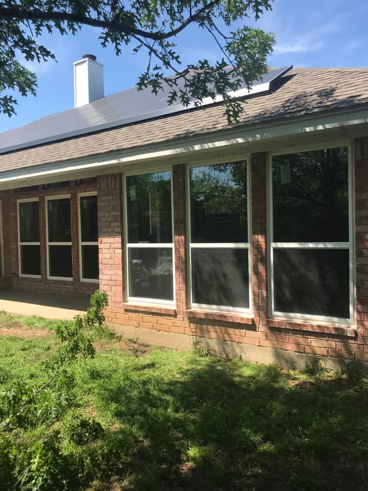 A brick house with a lot of windows and solar panels on the roof