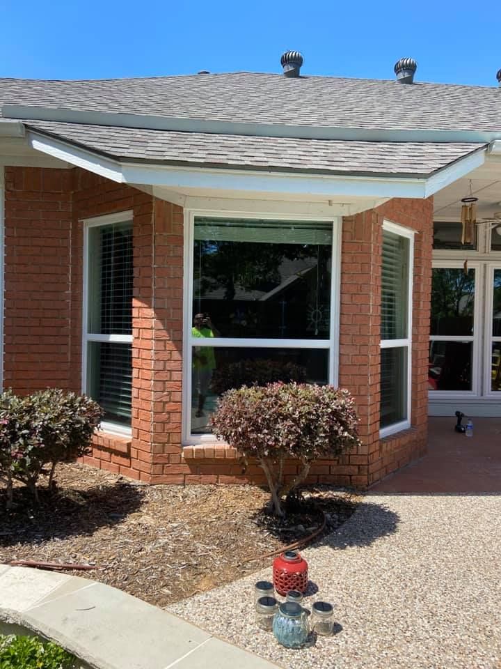 A red brick house with white windows and a gray roof.