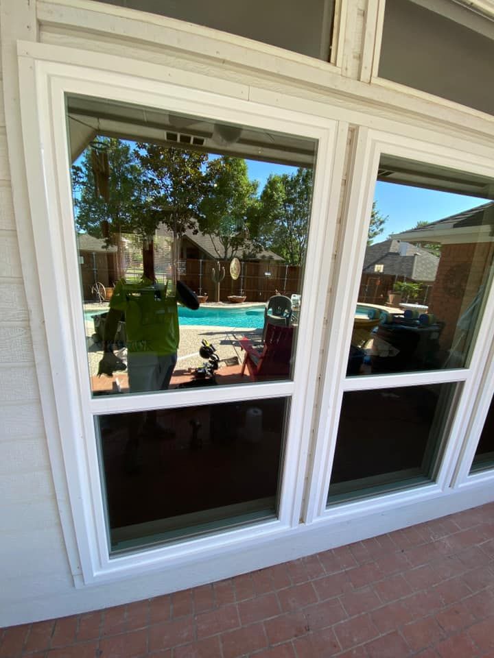 A white window with a view of a swimming pool.