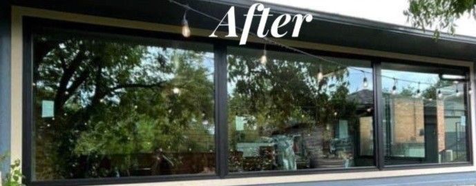 Exterior of a house with large black-framed windows reflecting trees and sky, with “After” text at the top.
