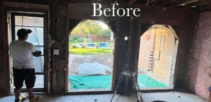 A man standing in a room with arched doorway openings, showing a backyard view. 