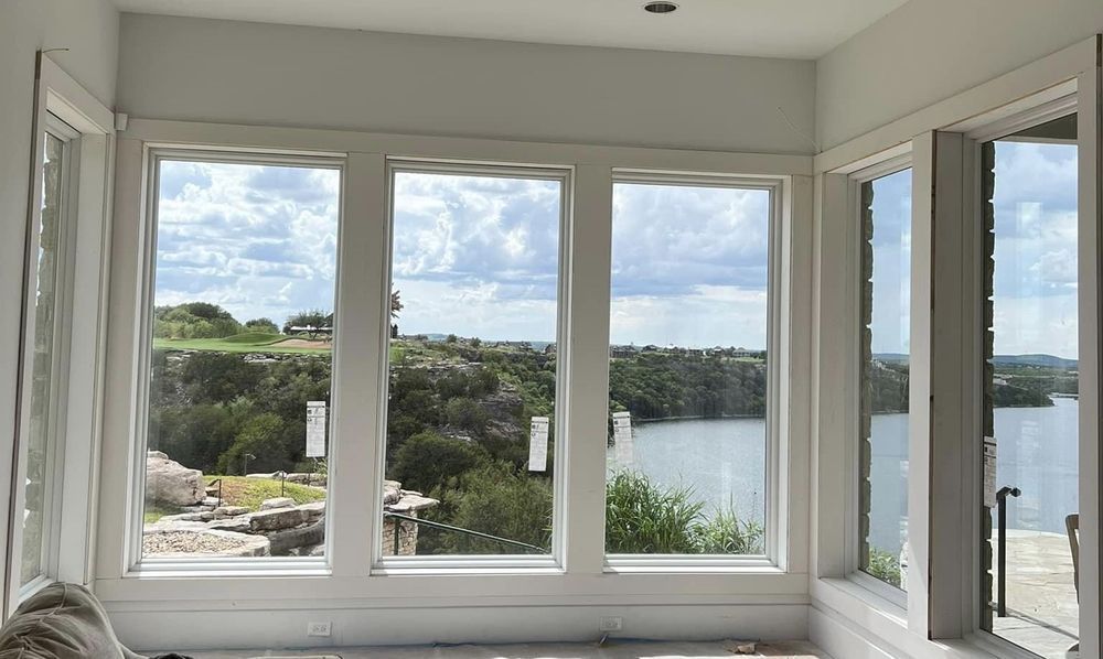 A room with a lot of windows and a view of a lake