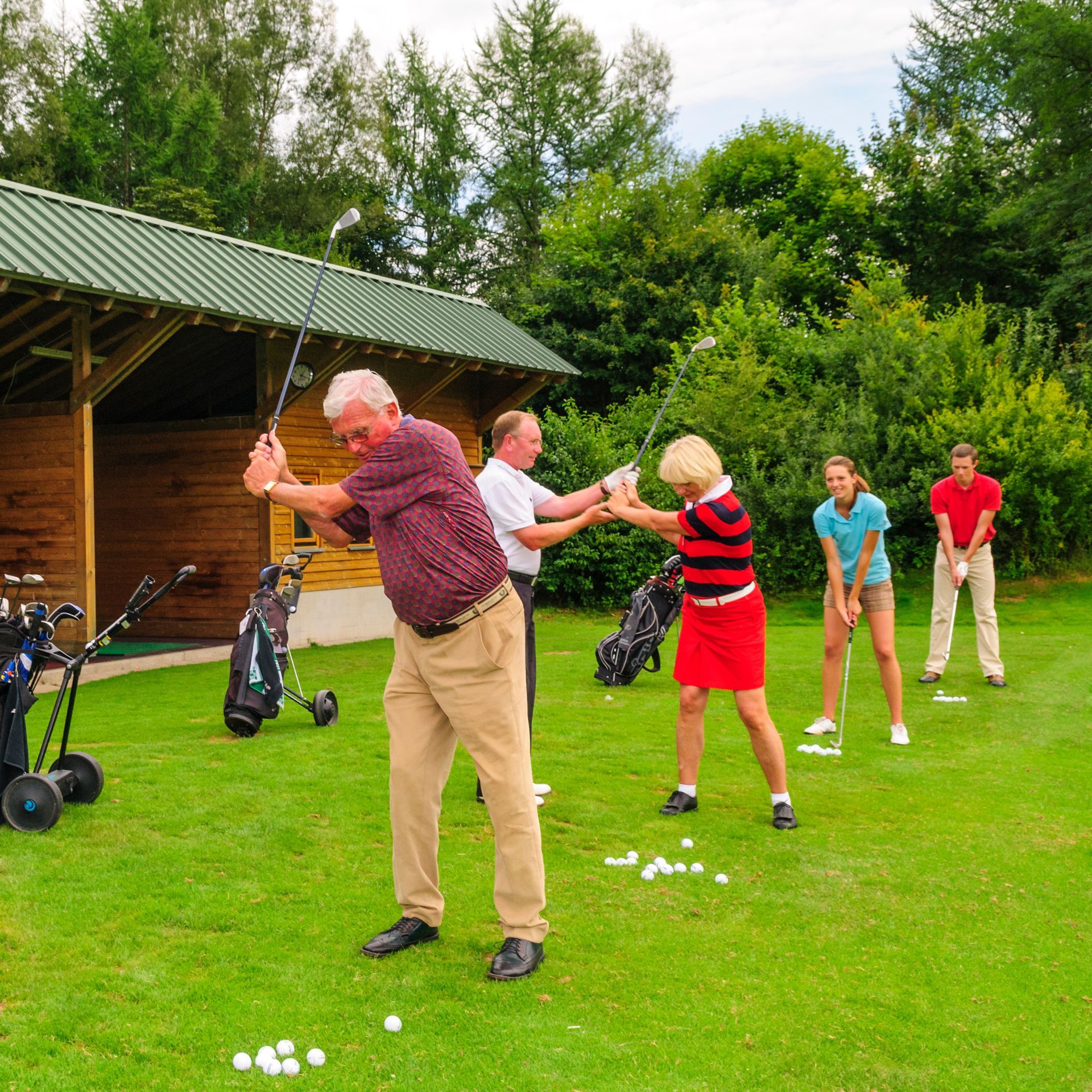 A group of people are playing golf on a lush green field