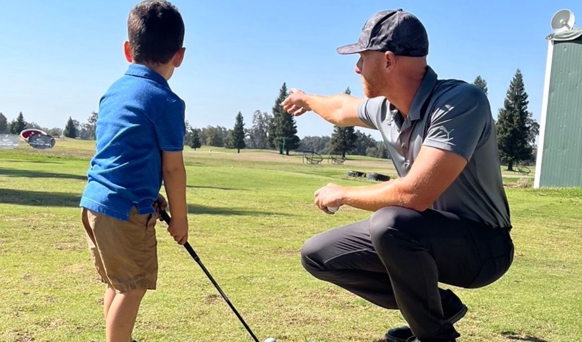Golf instructor Trevor Clayton giving junior golf lessons to inspire young players to enjoy the game.