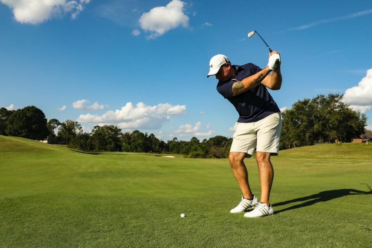 Golfer hitting a fairway shot, illustrating how smart tee time intervals with Fairway Control improve course flow and pace.