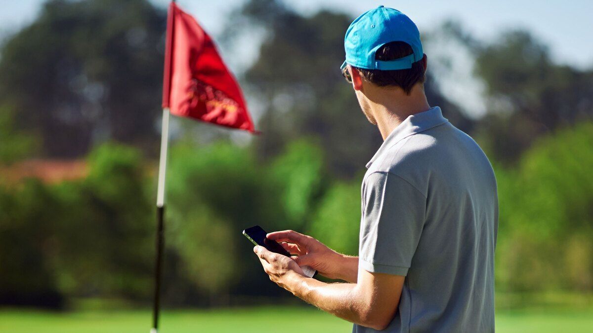 Golfer using a mobile golf app for shot tracking and course data
