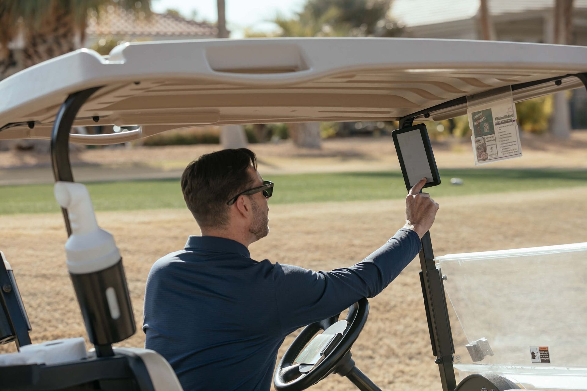 Golfer in a cart using GPS tracking system for course navigation