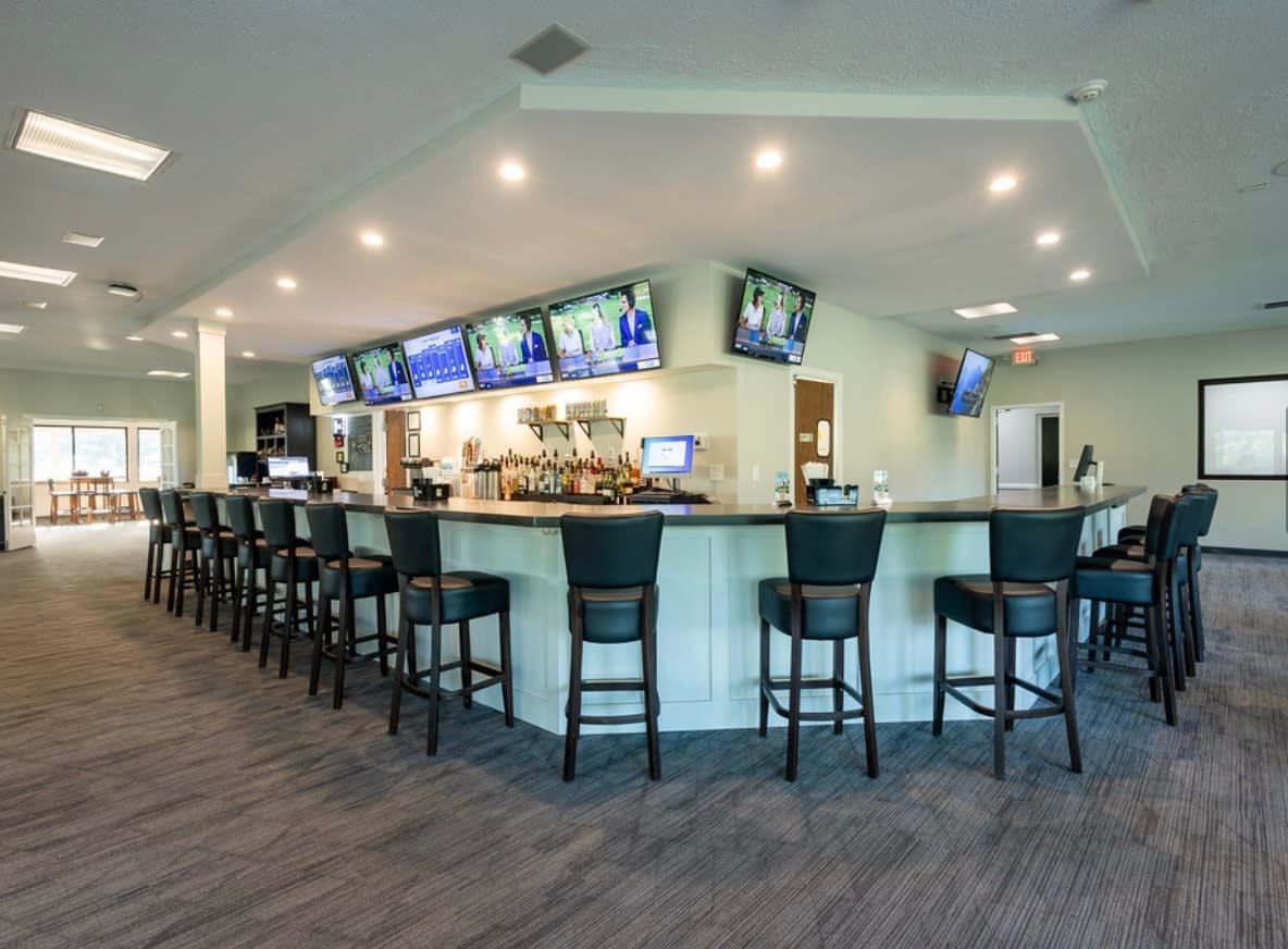 Golf club dining area and bar, blending casual service with elevated clubhouse atmosphere.