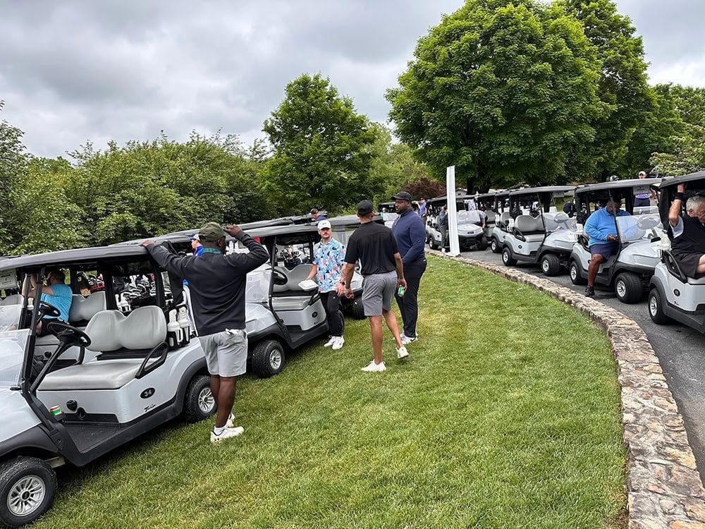 Golfers gathered at a Positive Coaching Alliance event at Bretton Woods Golf Course in Germantown, MD, enjoying a sunny tournament day.