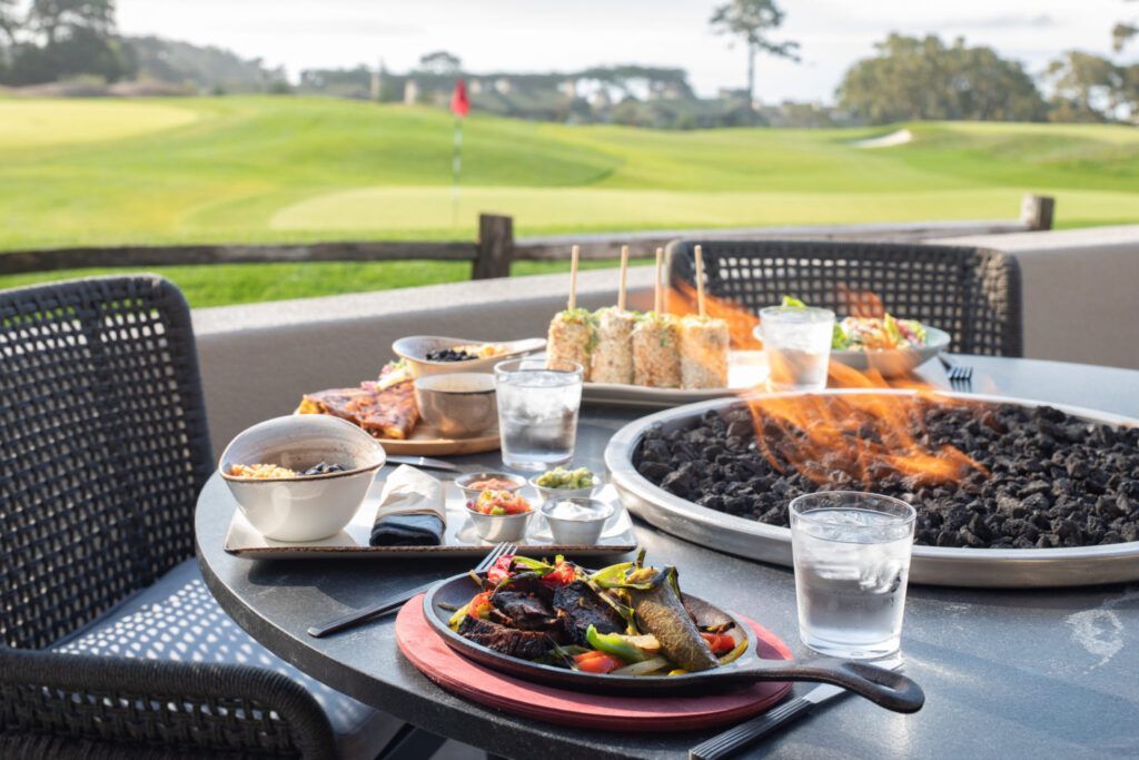 Beautiful golf course surrounded by trees and rolling hills under clear skies.