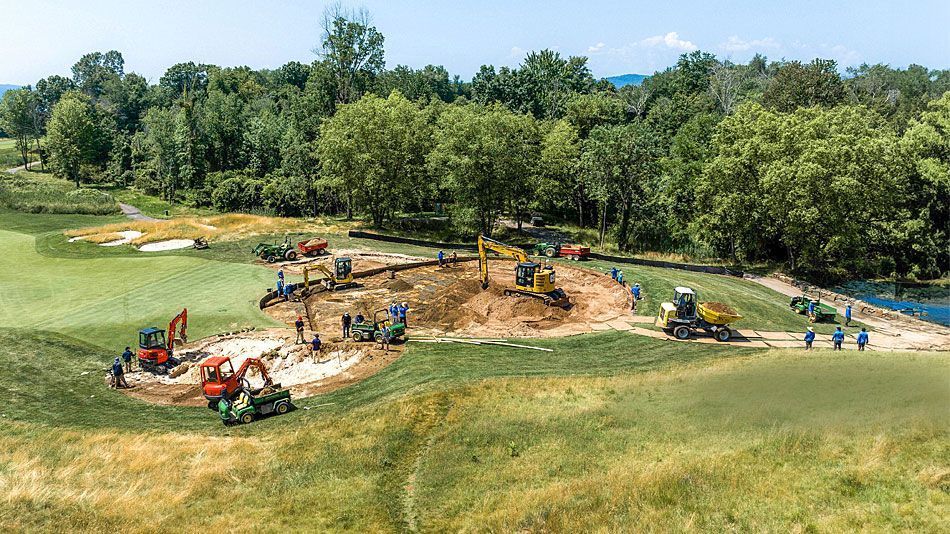 Construction workers renovating a golf course with heavy equipment and landscaping tools on-site.