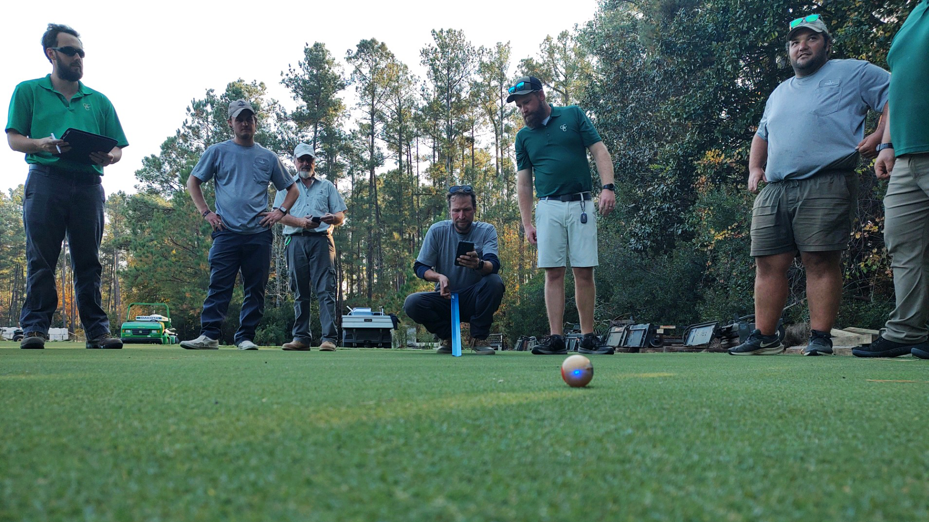 Golf staff using digital turf management tools during training.
