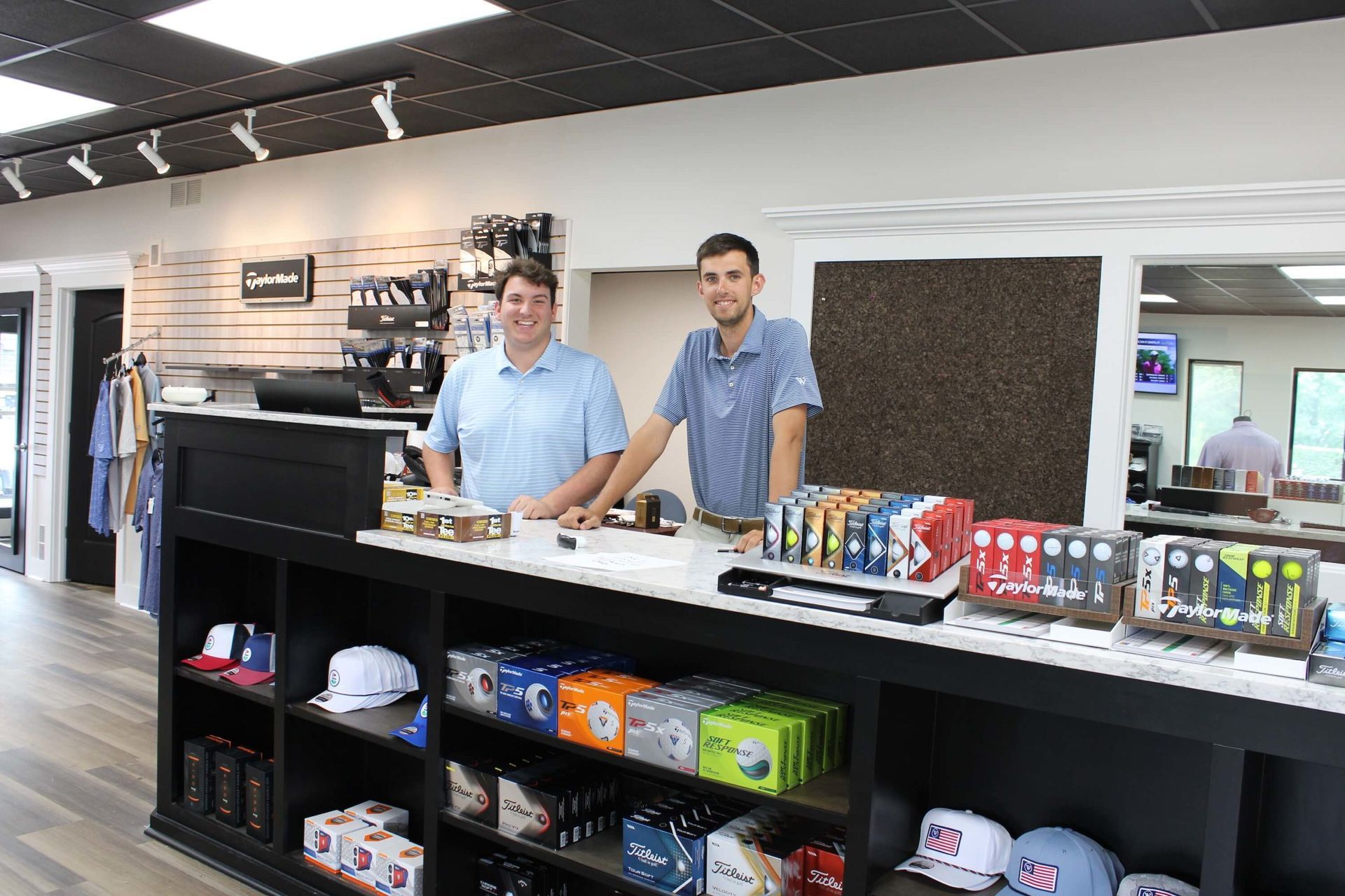 Smiling staff behind the counter at Wildwood Golf Shop in Louisville, Kentucky—representing the kind of guest service made more efficient with support from Fairway Control’s management tools.