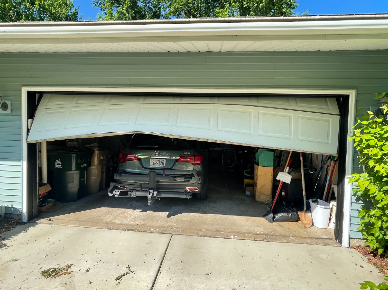 A car is parked in a garage with the door open.