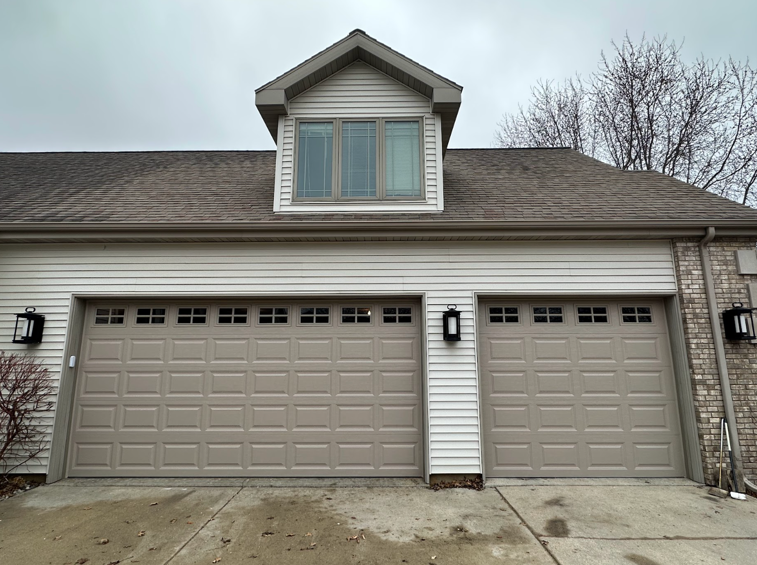 A house with two garage doors and a window on the roof.
