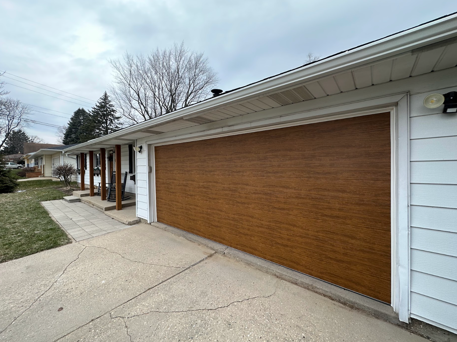 A large wooden garage door is on the side of a house.