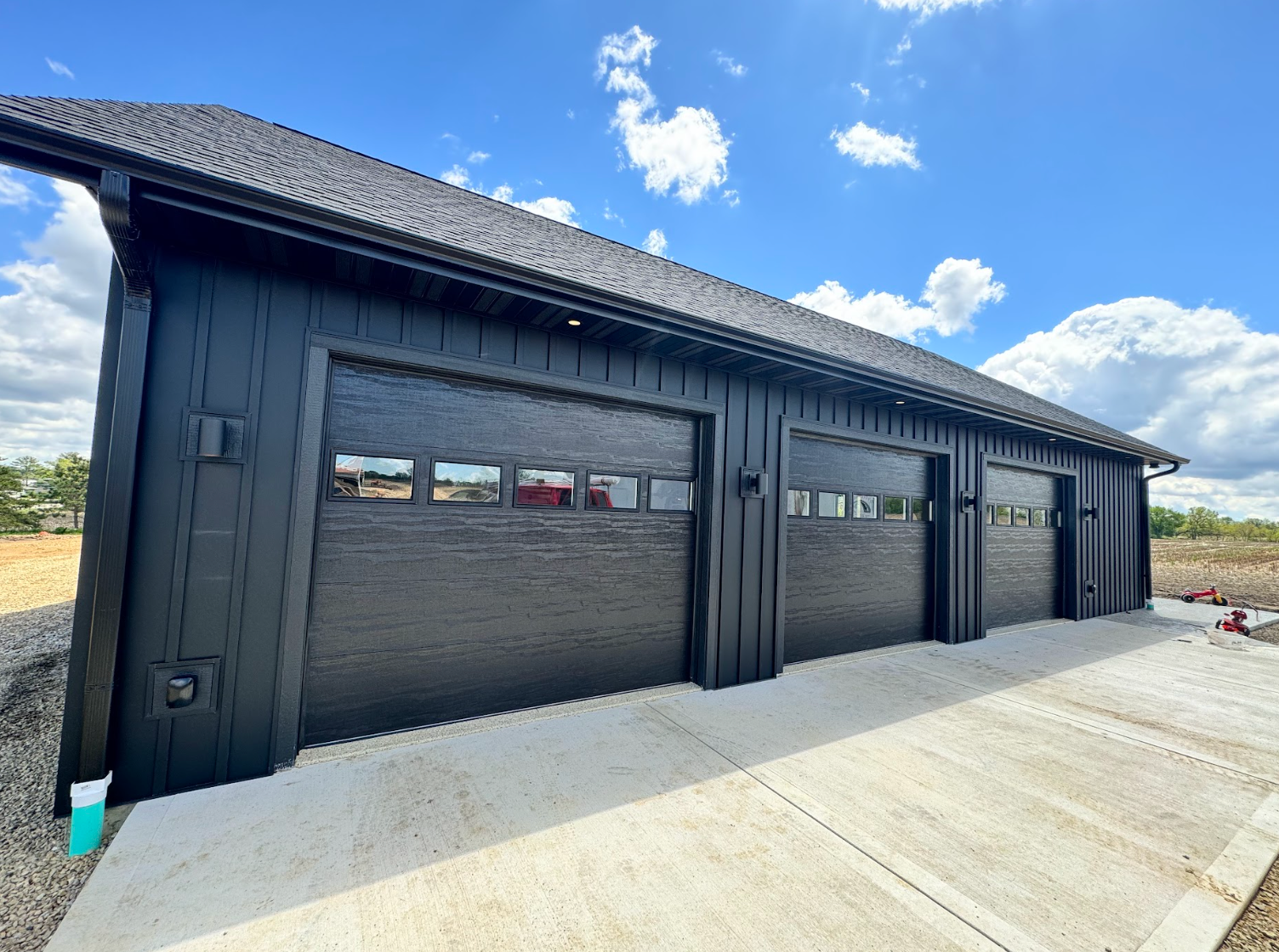 A row of black garage doors on a house.