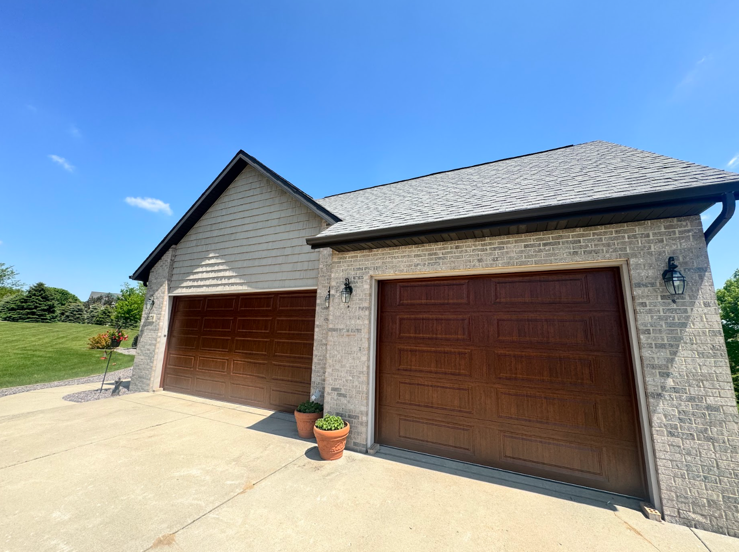 There are two garage doors on the side of a house.