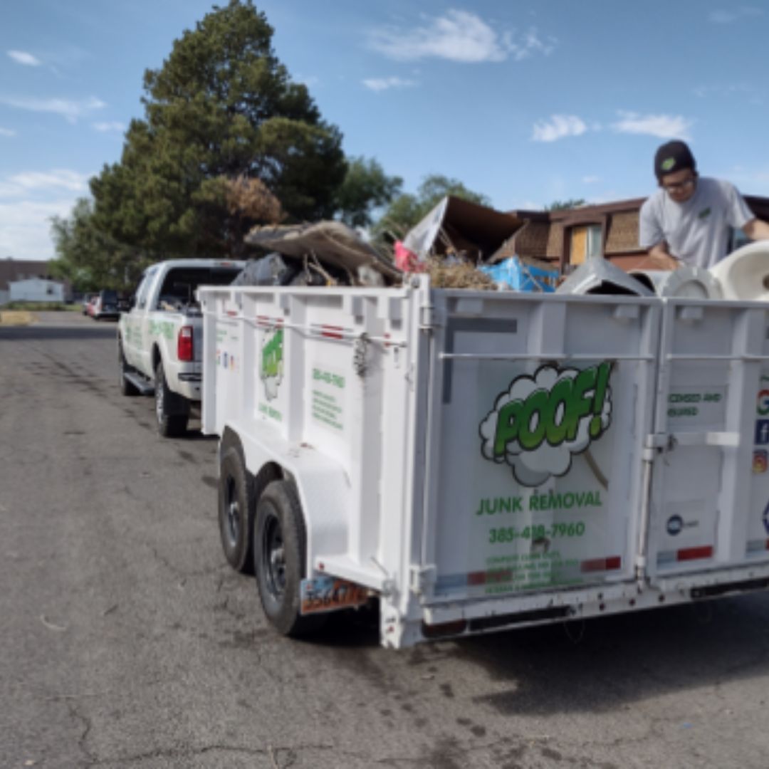 A junk removal trailer is pulled by a truck