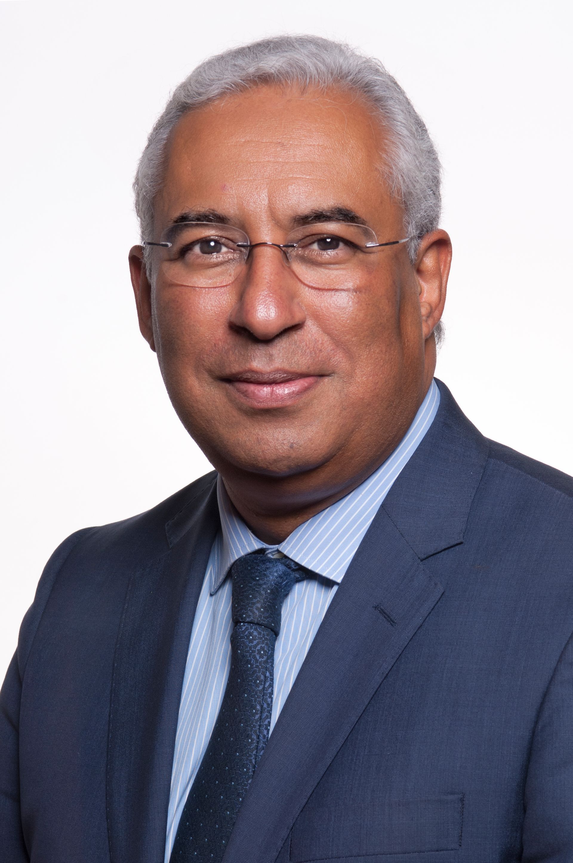 Retrato institucional de dirigente em contexto oficial, com iluminação sóbria