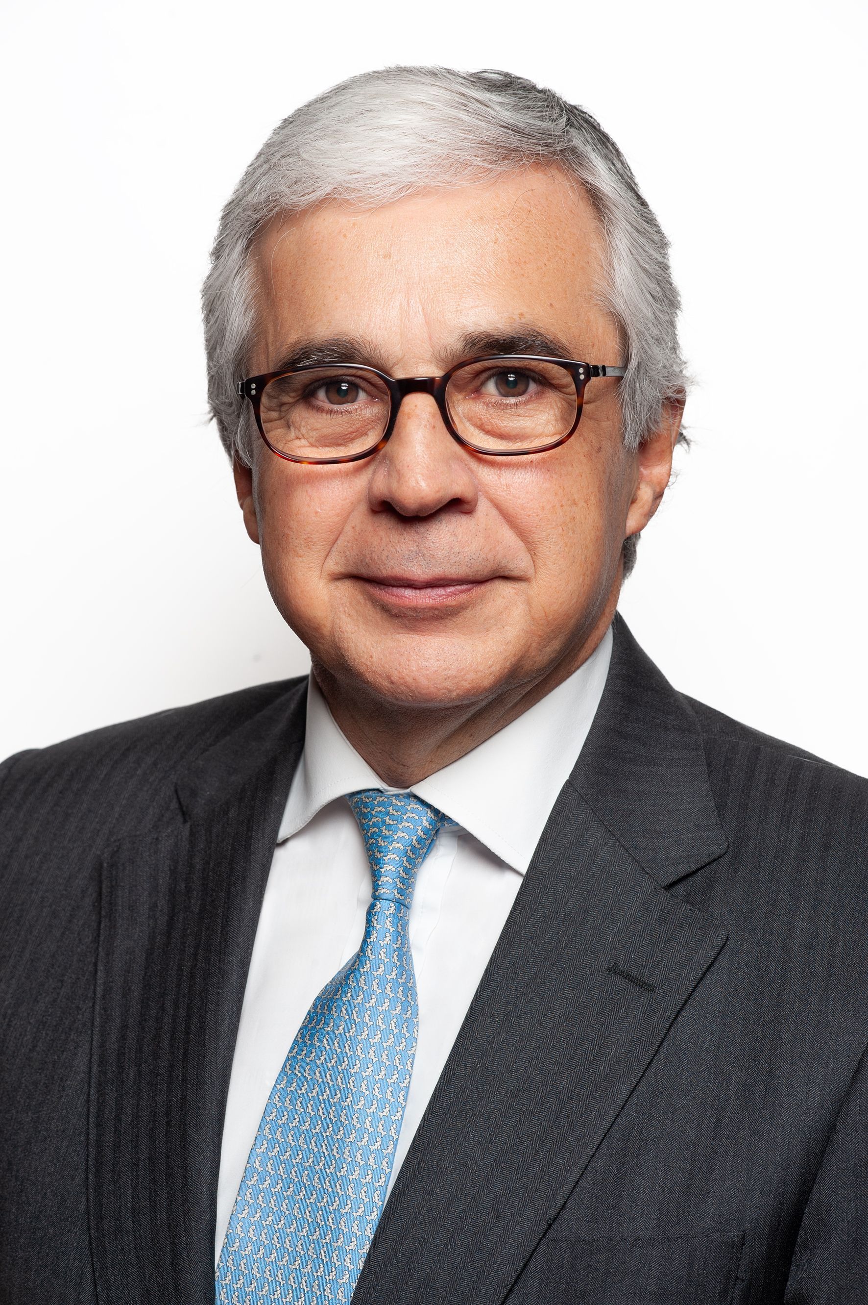 Retrato institucional de dirigente em contexto oficial, com iluminação sóbria