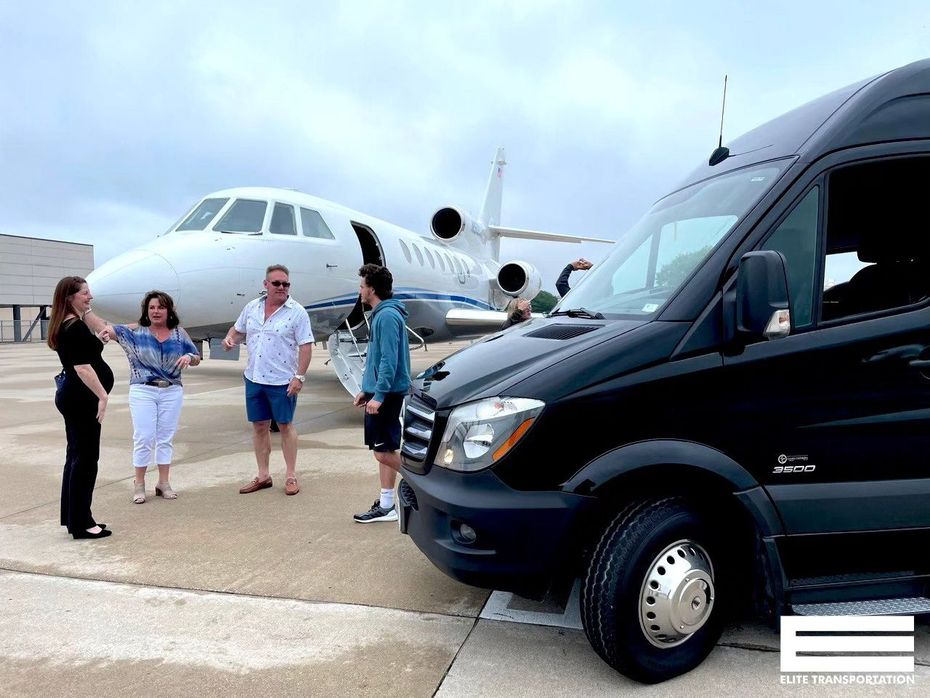 Black van parked near a private jet on a tarmac; people talking nearby.