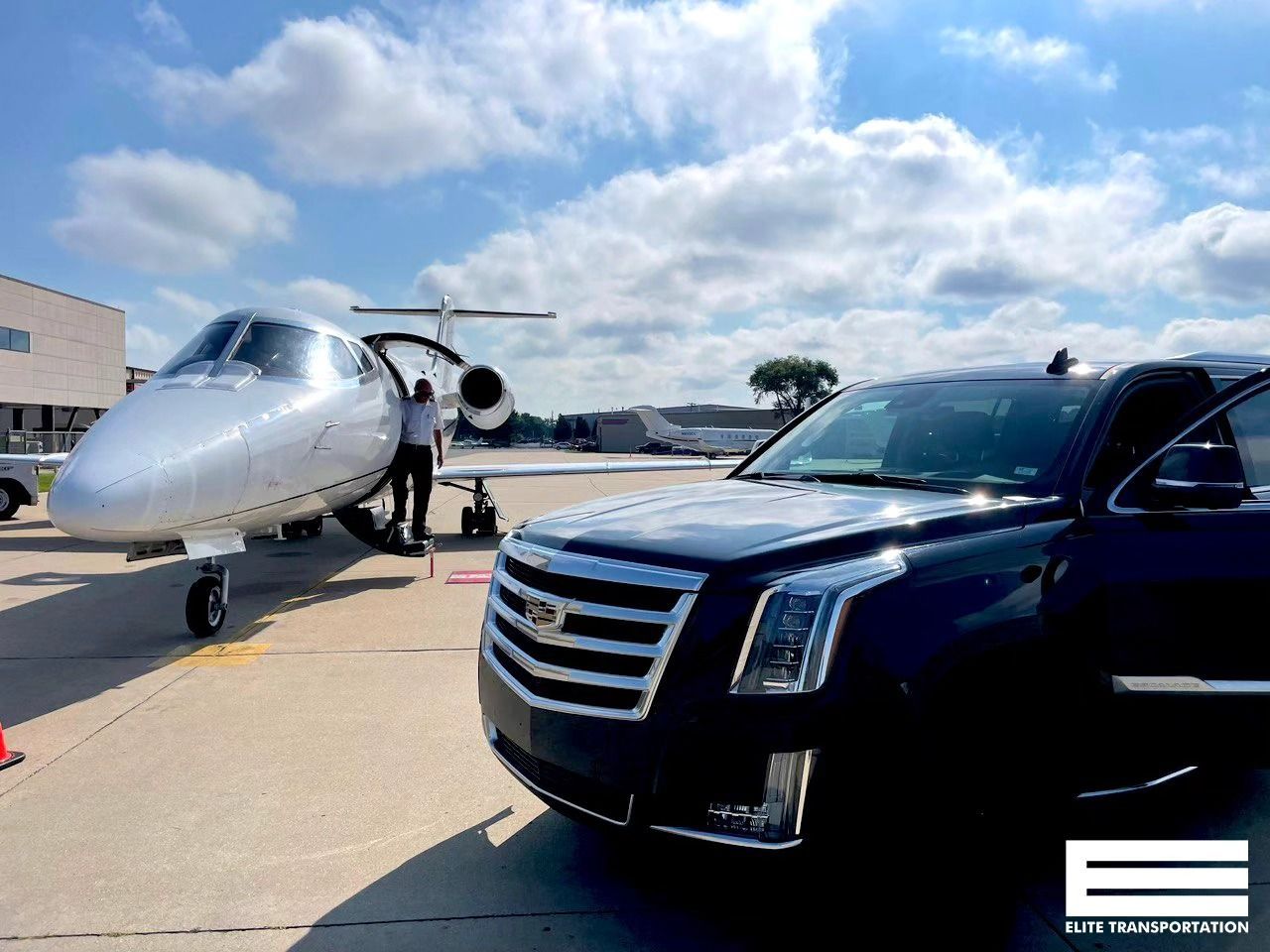 Interior of a luxury party bus with blue lighting, black diamond-stitched seating, and a bar area.