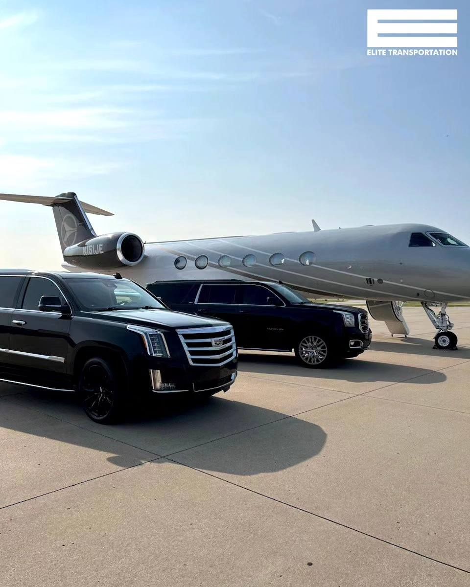 Two black SUVs parked in front of a private jet on a tarmac on a sunny day.