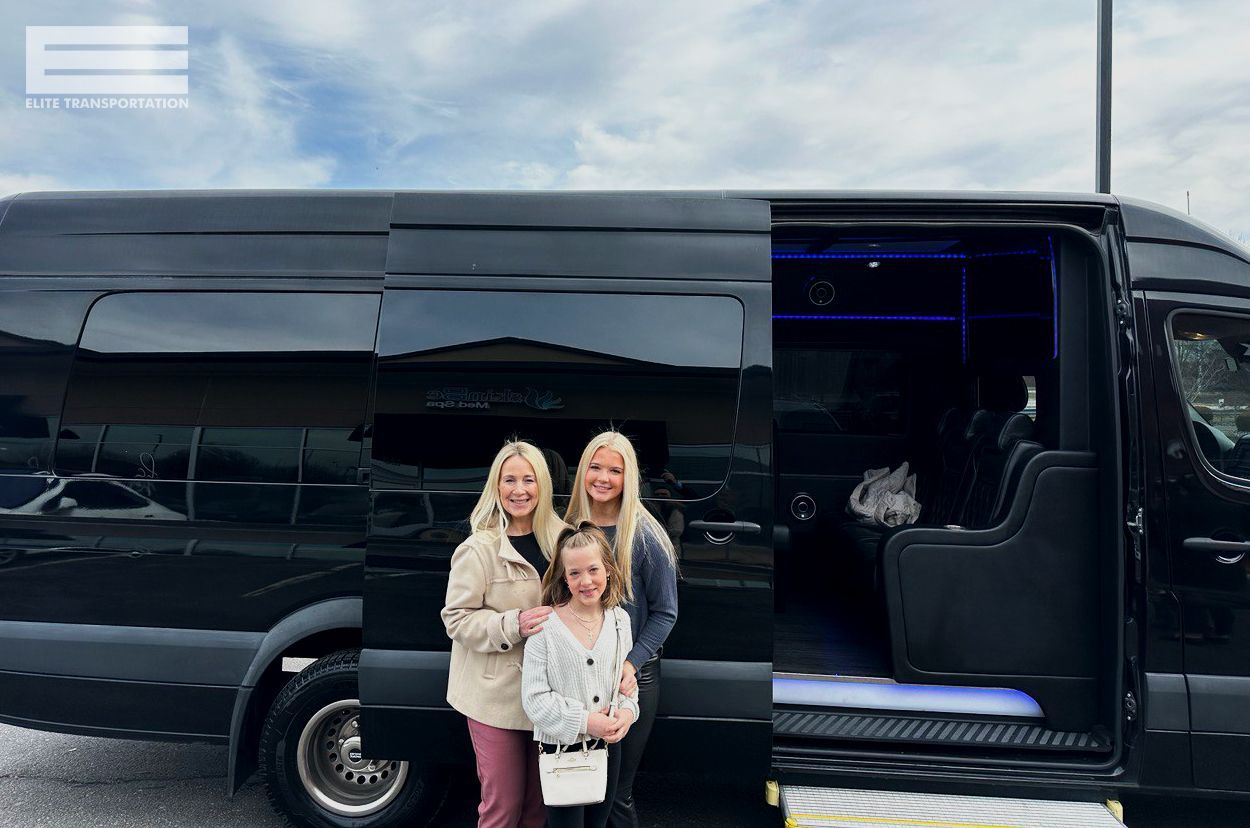 Three people stand in front of a black van with the sliding door open.