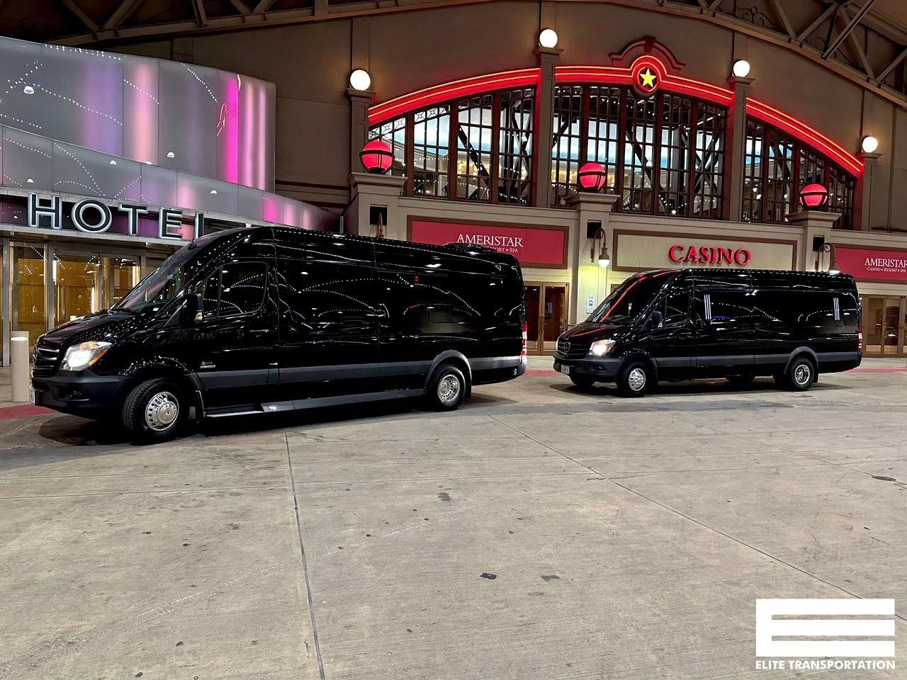 Two black vans parked outside a building with 