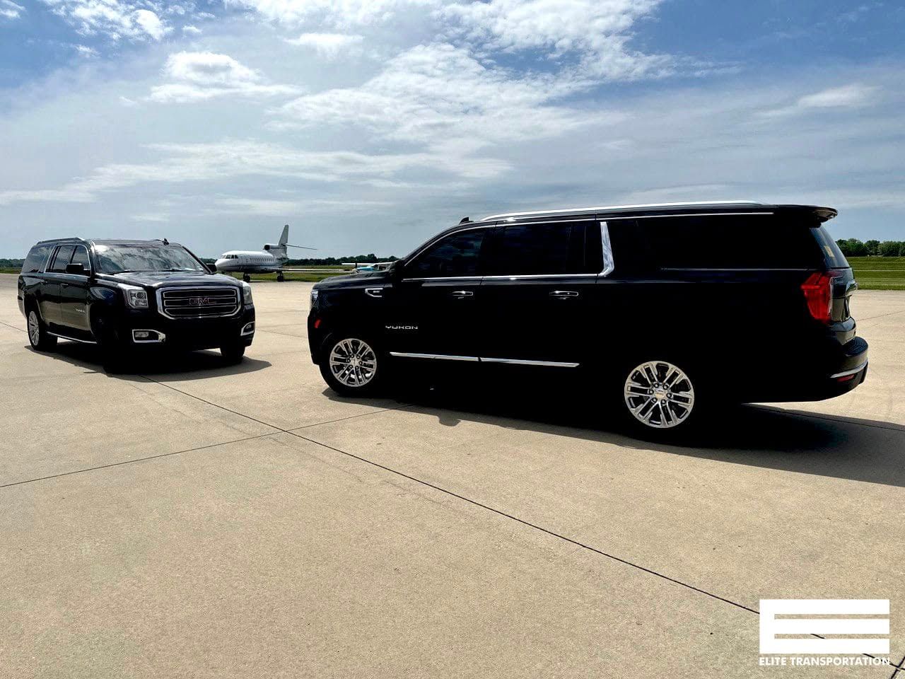 A group of children posing beside a black limousine on a gravel lot under a clear sky.