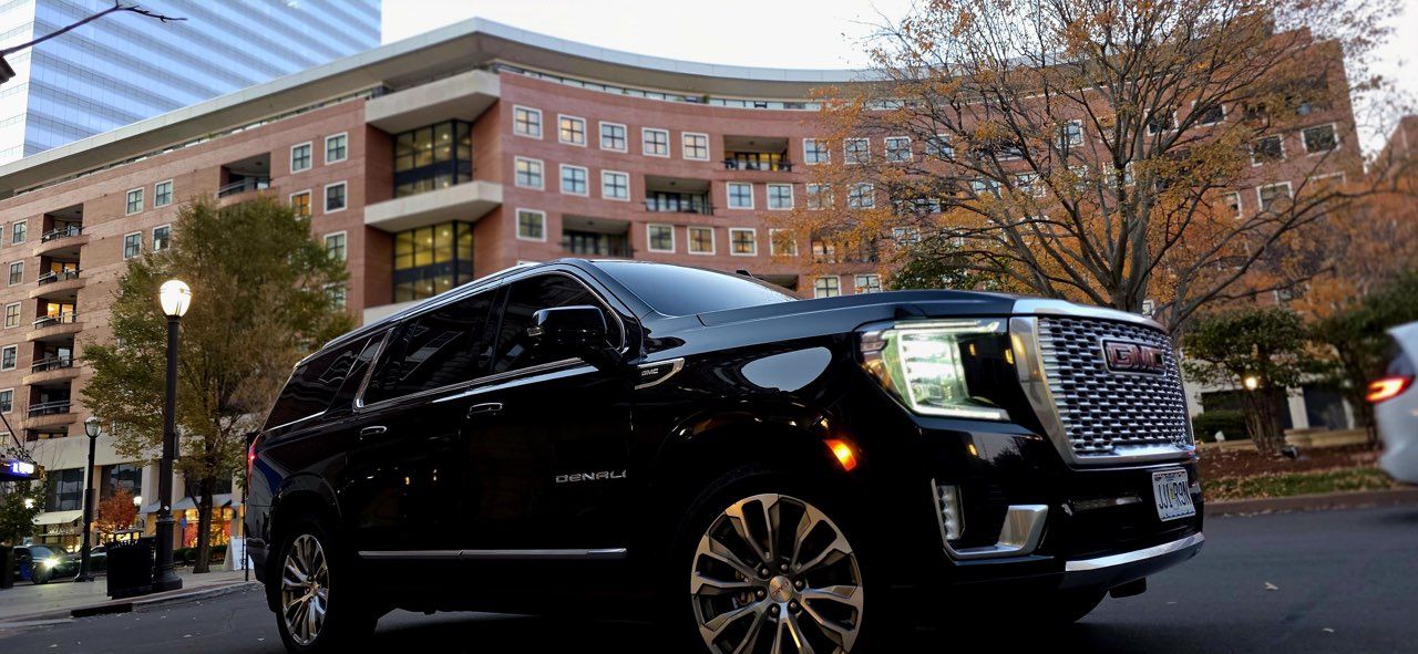 Black SUV parked on a city street with brick buildings in the background