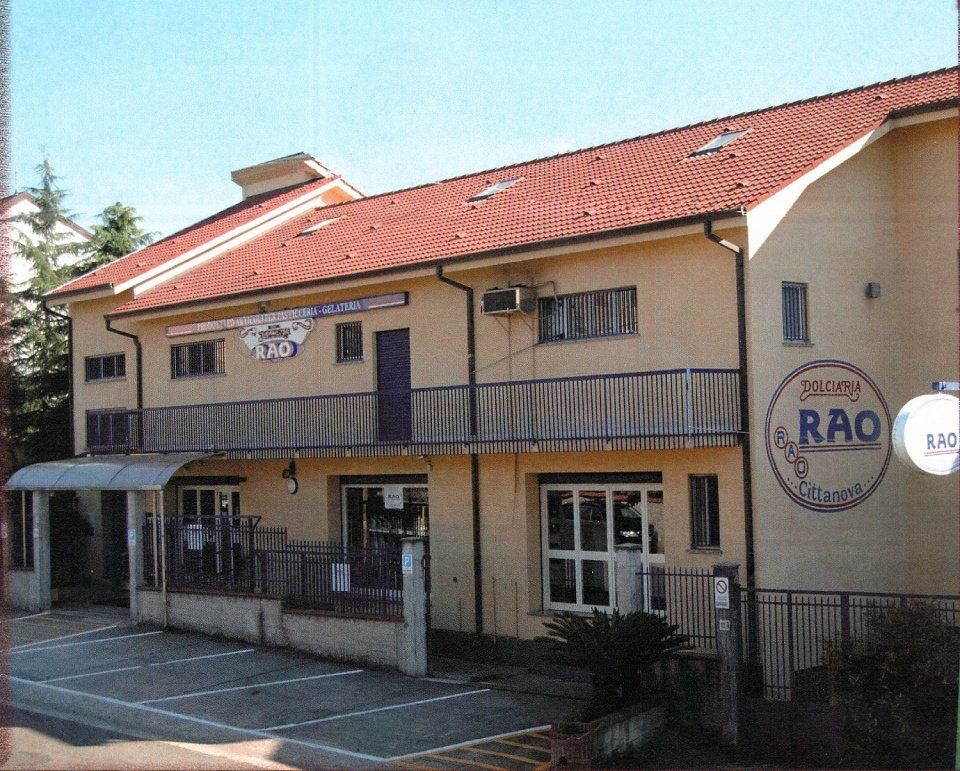 edificio a due pieni in giallo con tegole rosse