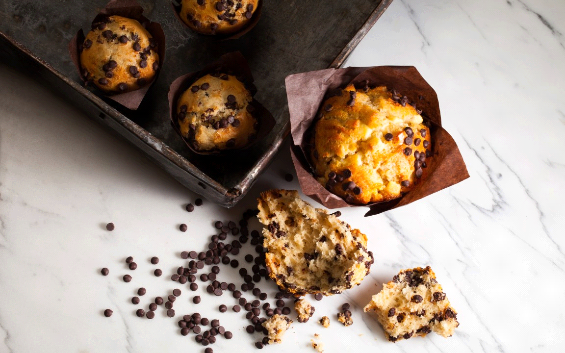 un tavolo di marmo con sopra dei muffin con gocce di cioccolato