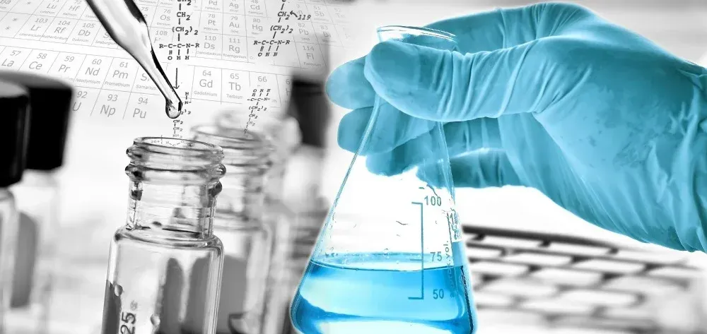 A person is pouring liquid into a beaker in a laboratory.