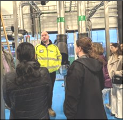 A man in a yellow jacket is talking to a group of people