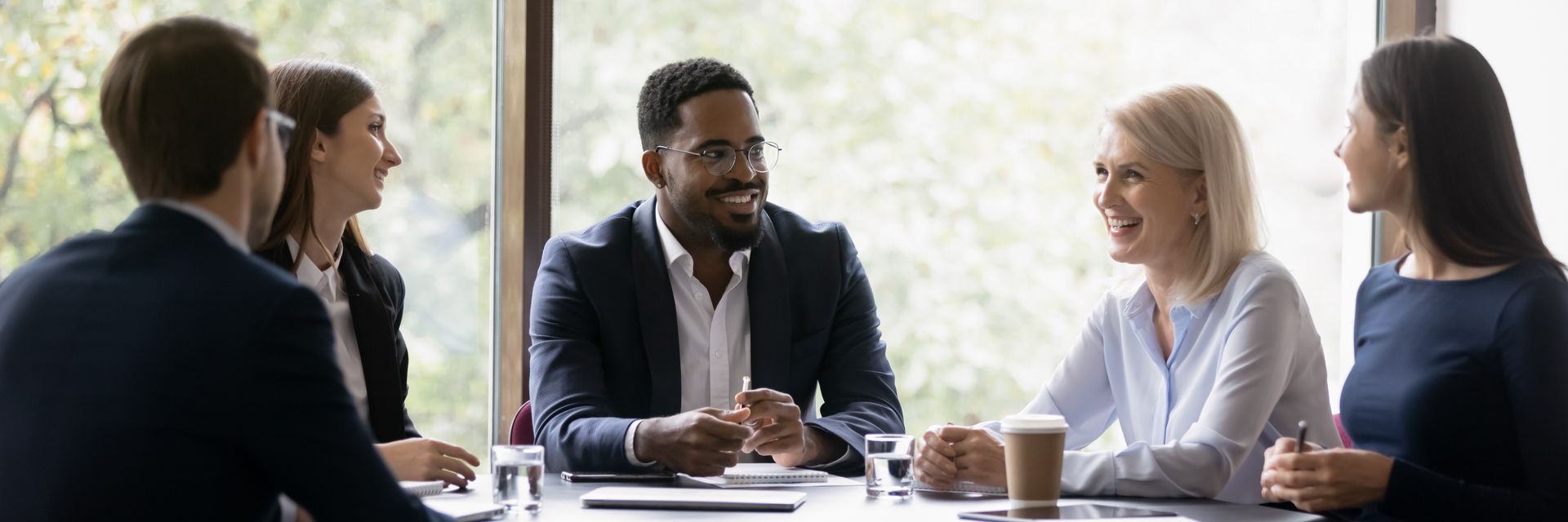 A group of people are sitting around a table having a meeting.