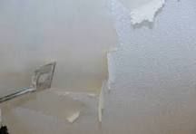 A scraper removing a popcorn ceiling