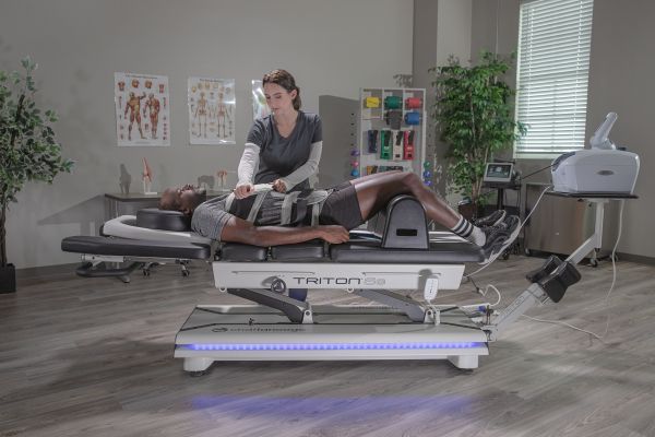 Una donna è sdraiata su un letto e riceve un trattamento di drenaggio linfatico.