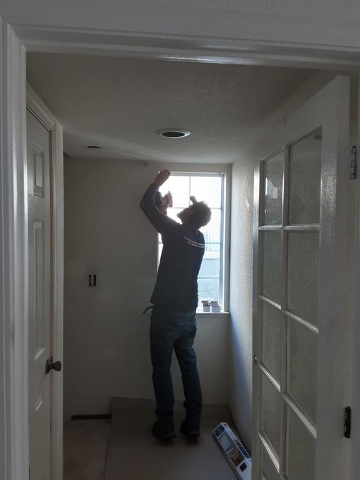 A man standing in a hallway looking up at the ceiling