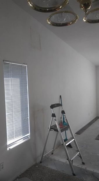 A ladder is sitting in front of a window in a room.