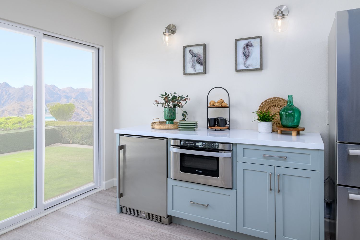 image of a small cabinetry unit -serving station-encasing a beverage fridge and  microwave drawer,  light green cabinets in a kitchen with white quartz countertops, light tan and gray luxury vinyl flooring,  Rancho Conejo Neighborhood, Newbury Park, CA, open and airy kitchen remodel 