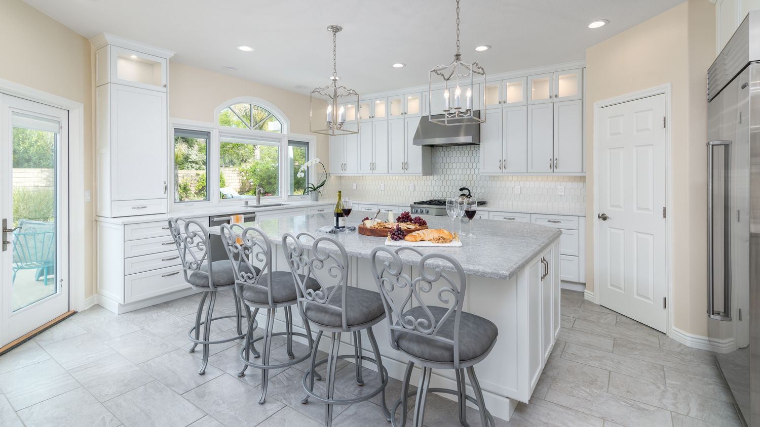 image shows a large white kitchen with island and 4 barstools in the foreground, Newbury Park, CA, Open Concept Kitchen Expansion and Remodel