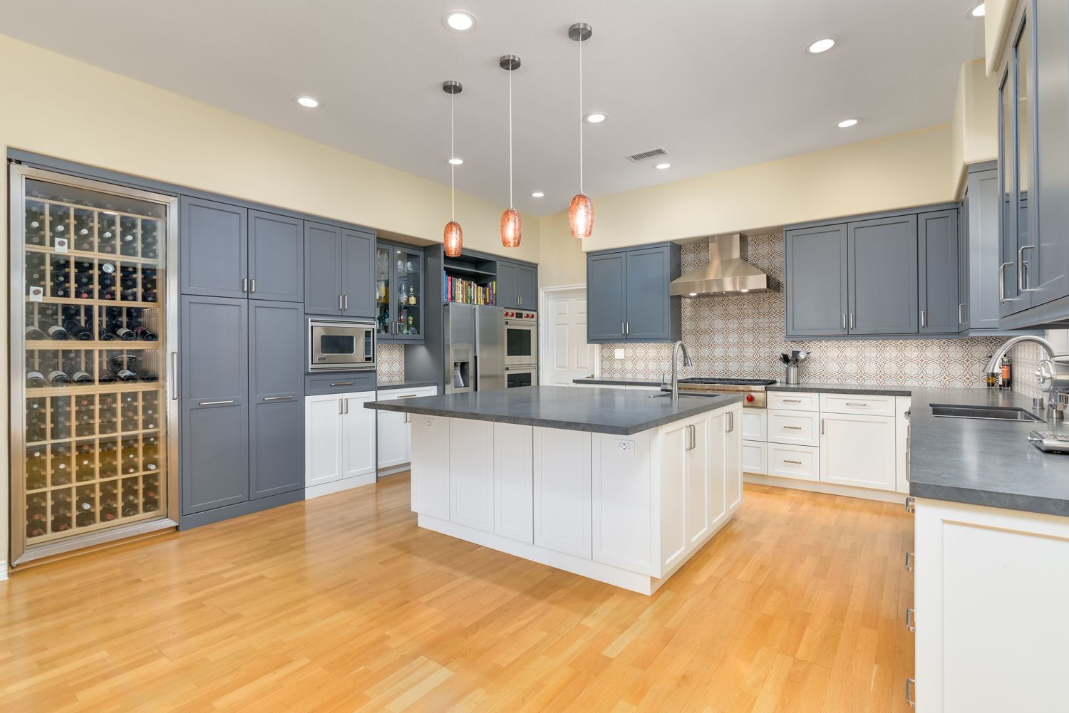 image shows a large gray and white open-concept style kitchen, light colored wood floors, patterned accent tile, pendant lights, kitchen island, stainless steel appliances, Kitchen Remodel, Dos Vientos Neighborhood, Newbury Park, CA 