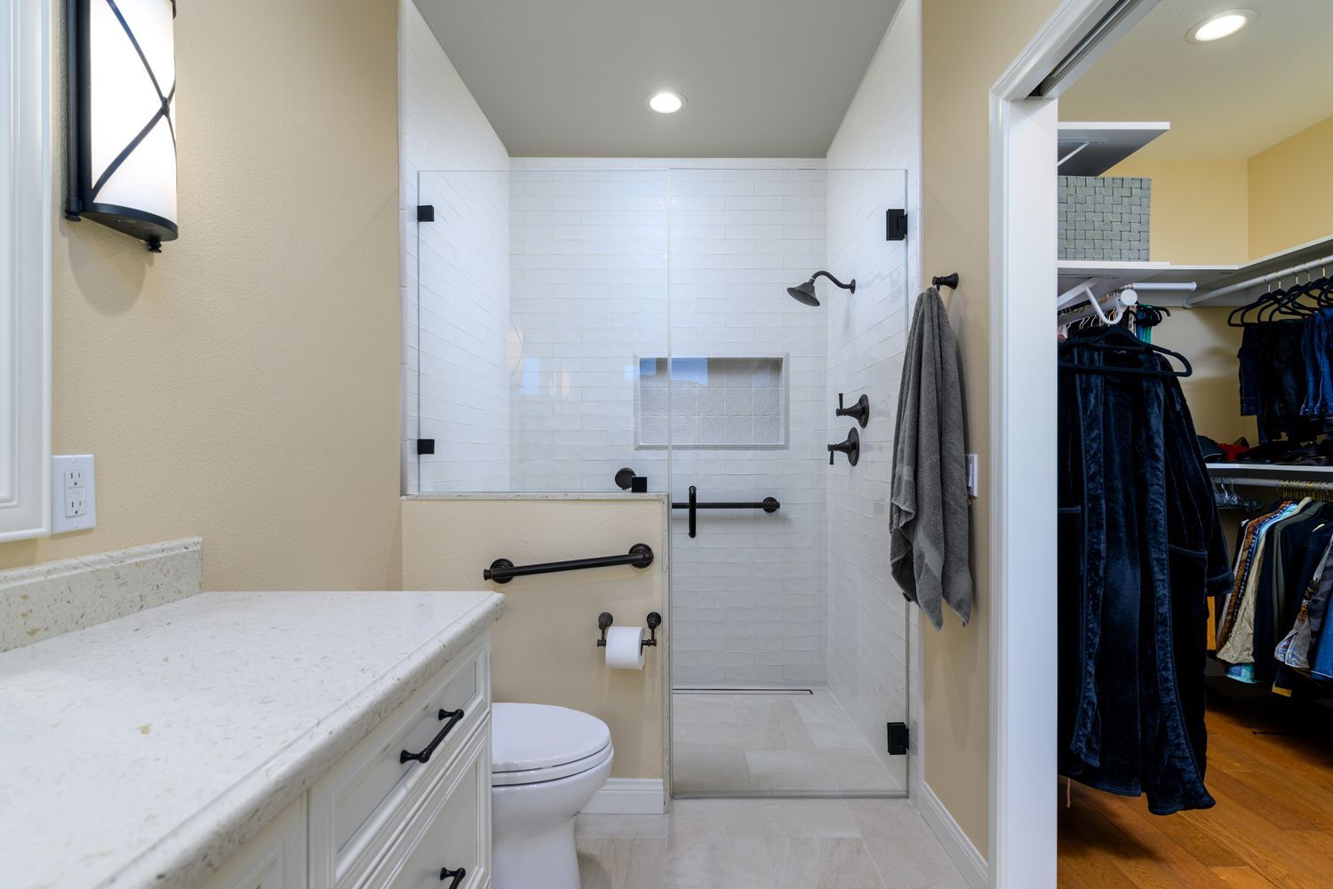  Image of a  classy, tranquil master bathroom, muted shades of ivory and beige, ivory colored subway shower tile, ivory toned vanity by Omega Cabinetry, quartz countertop by Pental Surfaces, grab bars, non-slip flooring, curbless shower, shampoo niche, new walk-in closet, master bathroom addition, Thousand Oaks, CA, walk in closet addition, Aging-In-Place Bathroom Addition & Remodel