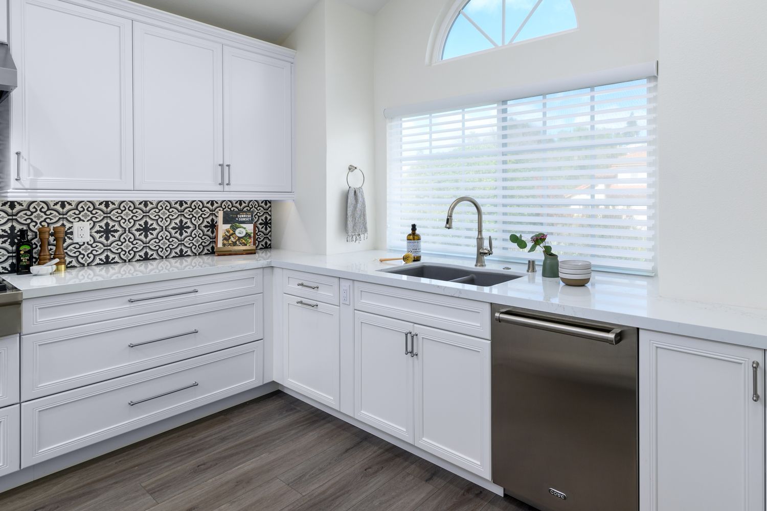 image of a kitchen sink under a window, white cabinets, white quartz countertops, blue and red and white floral backsplash, stainless steel dishwasher, Thousand Oaks, CA kitchen remodel, 