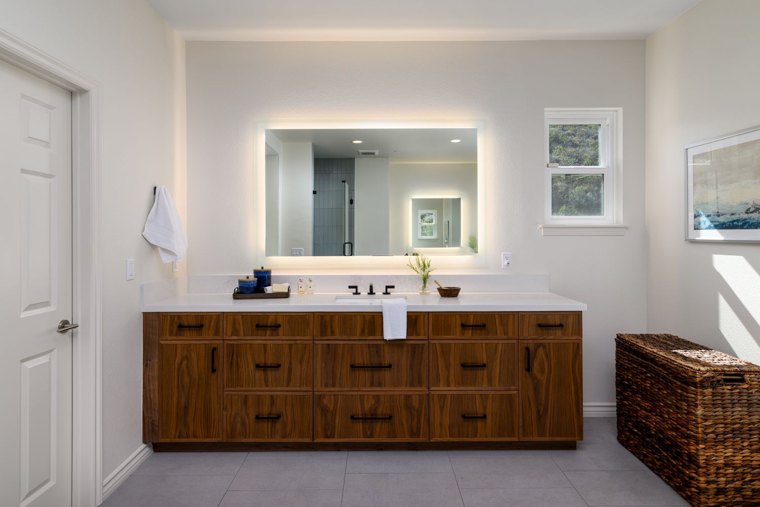 image shows a walnut wood vanity, white quartz countertops, lighted mirror, primary bathroom remodel, Thousand Oaks, CA 