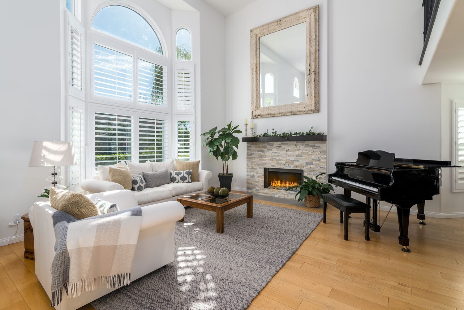 image shows an inviting and bright Living Room with High Ceilings, a Fireplace & big Windows with white blinds and a baby grand piano, Oak Park, CA  Kitchen Remodel  