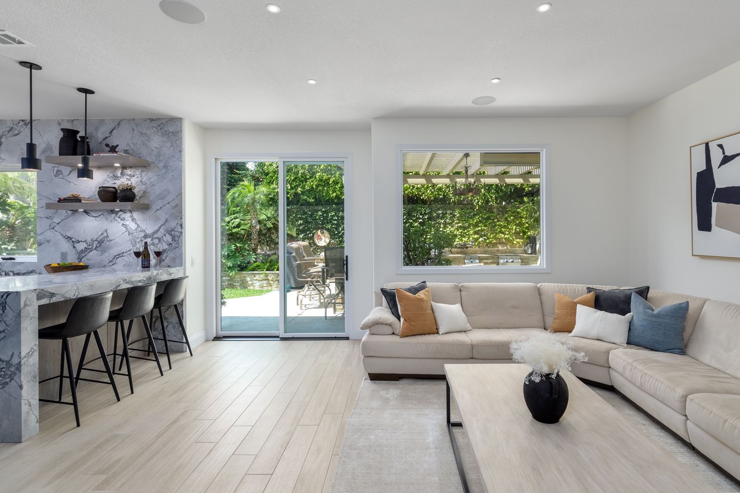 image of a modern style living room with a view to the backyard and kitchen peninsula with marble backsplash, modern living room design, Newbury Park, CA Living room Remodel, Kitchen Remodel,  