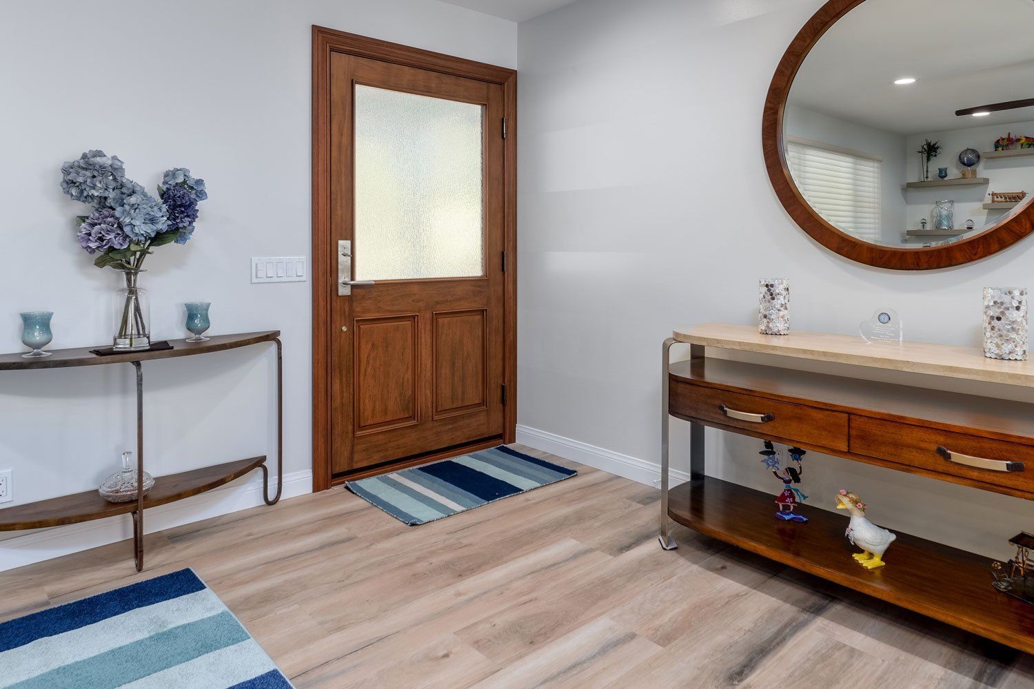 image shows an Entry Way with a new wood Front Door, wood Mirror & Luxury Vinyl Flooring, West Hills,CA Home Remodel 